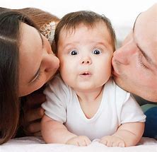 Parents kissing baby